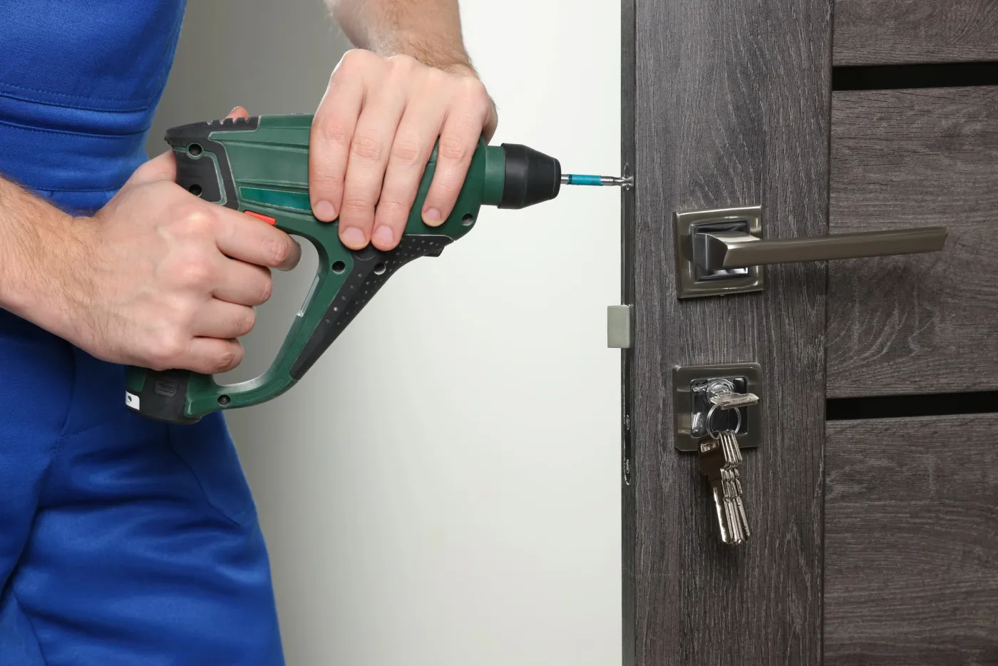 Serrurier fixant une serrure de sûreté sur une porte de logement à Trappes